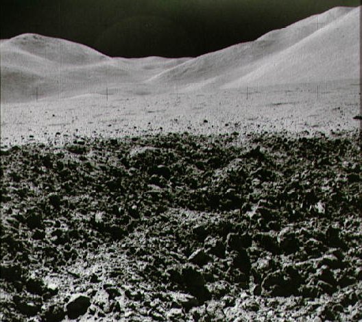 Cratère récent sur fond de montagnes ( photo NASA )